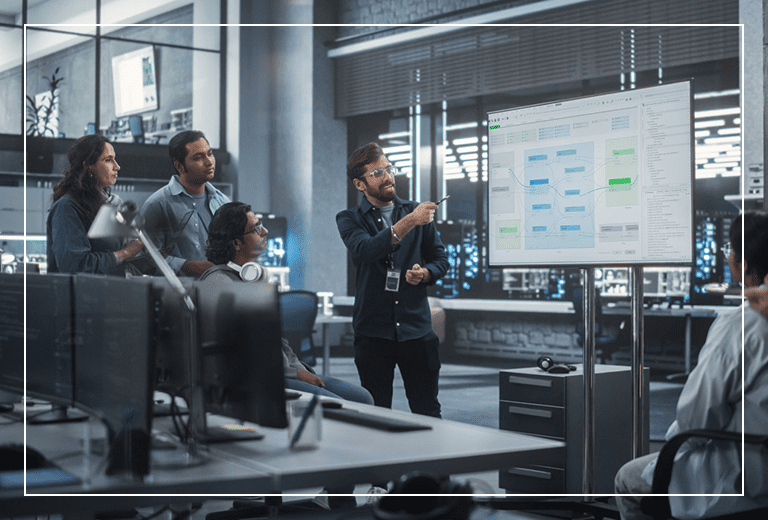 Team discussing data on large display screen.