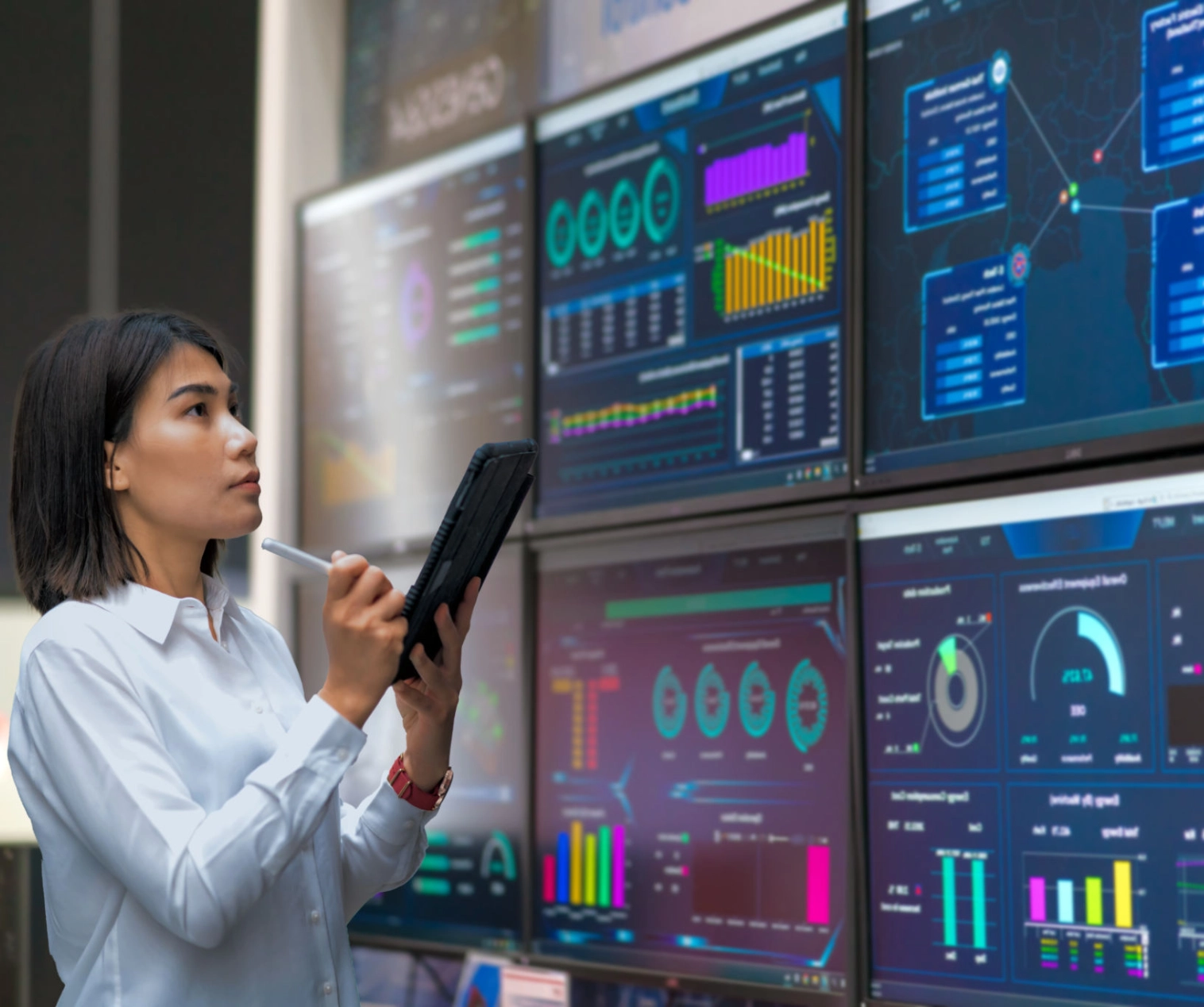Woman analyzing data on multiple screens.
